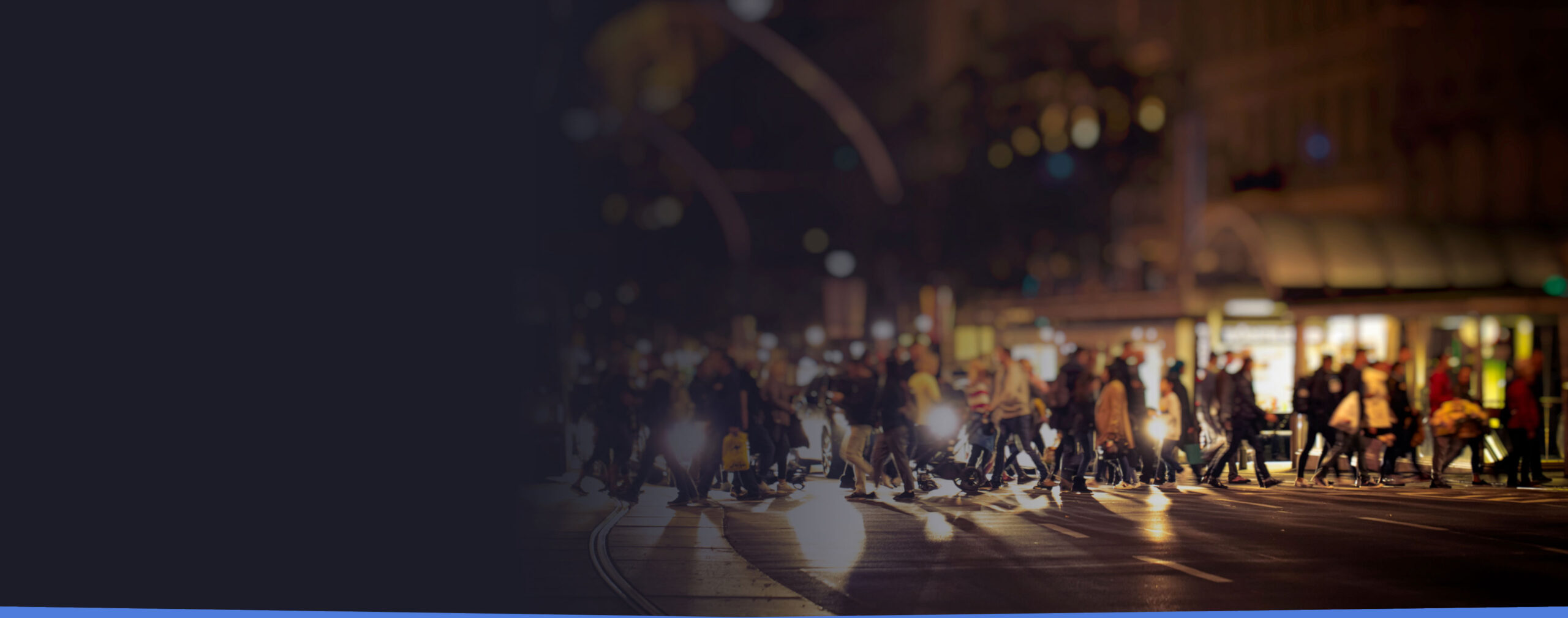 People crossing street in the evening with lights shining through